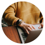 Person som arbetar vid laptop vid ett bord.