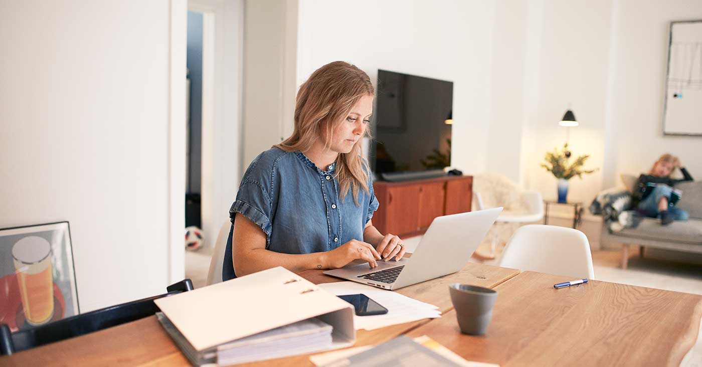kvinna sitter med dator och pärmar
