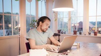 Man skriver på laptop