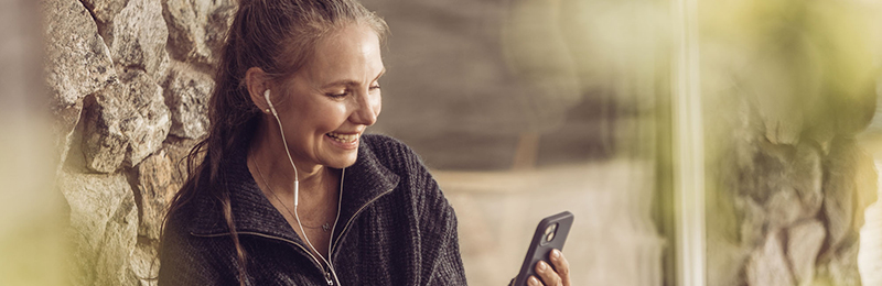 Kvinna har videosamtal eller möte i mobilen med heandset och ler