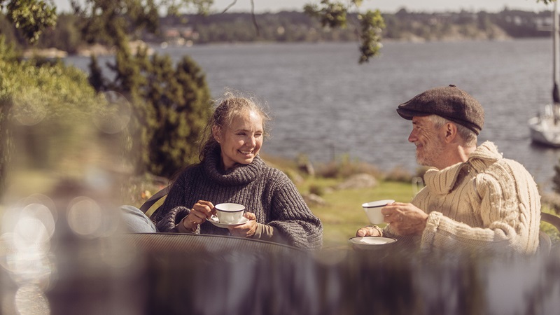 en man och en kvinna sitter ute och fikar