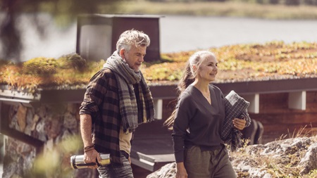 kvinna tittar på surfplatta i trädgård