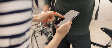 person pekar på mobilskärm