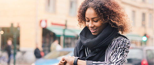 kvinna på stan tittar på mobil