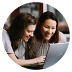 Två personer sitter tillsammans och tittar på en laptop.