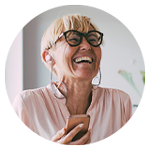 Kvinna håller i en mobiltelefon och bär hörlurar.