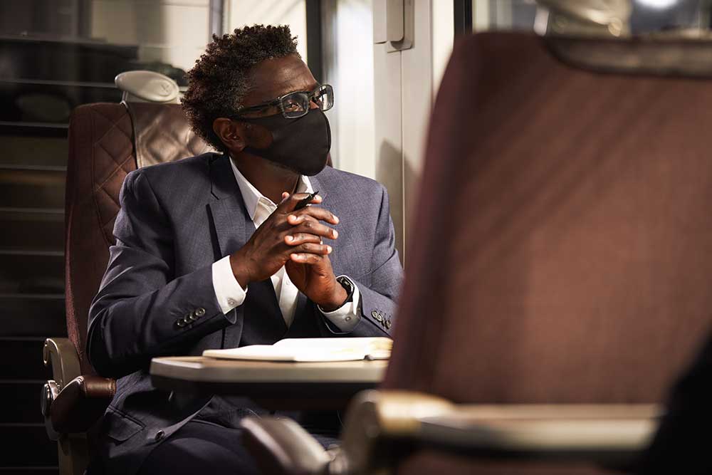 man med munskyd jobbar på tåg