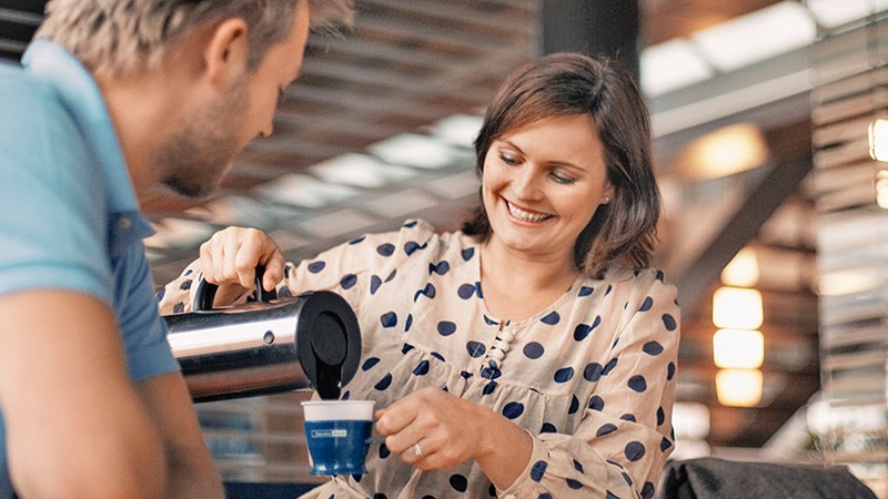 kvinna häller upp kaffe