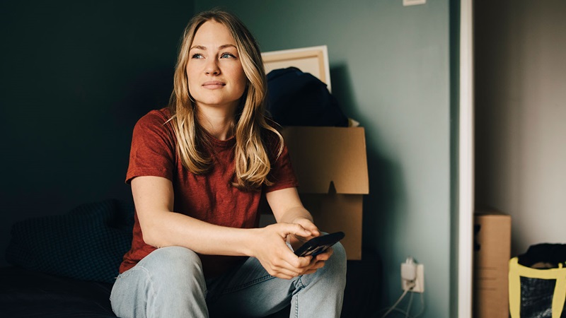 tjej sitter med mobil i händerna