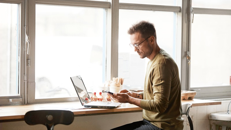 Man sitter med laptop på cafe