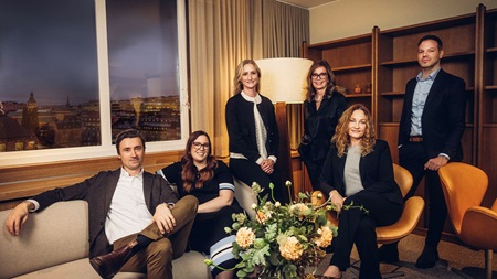 Grupp av premiumrådgivare samlade i ett modernt mötesrum.