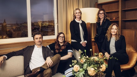 Grupp av premiumrådgivare samlade i ett modernt mötesrum.