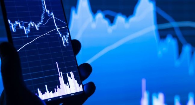 Hand som håller mobil med diagram på skärmen