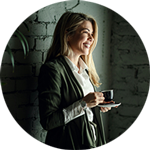 Kvinna står med kaffekopp i handen