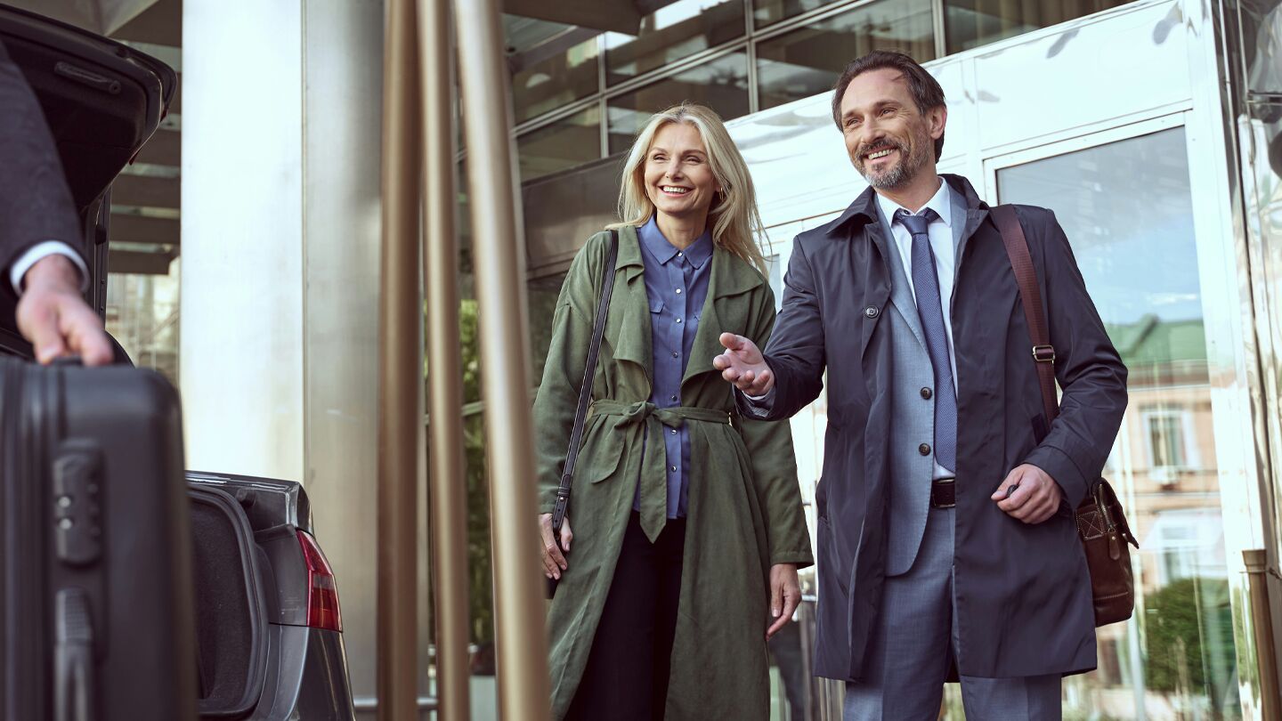 Person lastar ur resväskor vid en hotellentré.