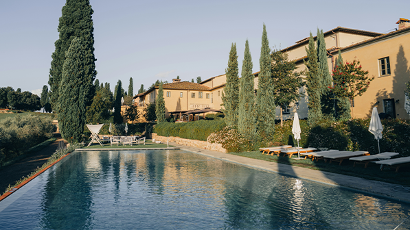 Kammusslor serverade på is med svart rom på en blå tallrik.