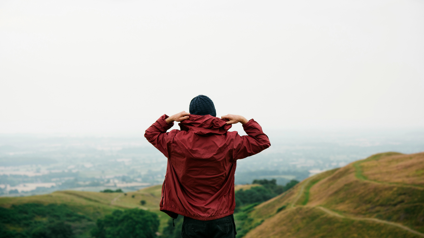 Man står och kollar ut över berg