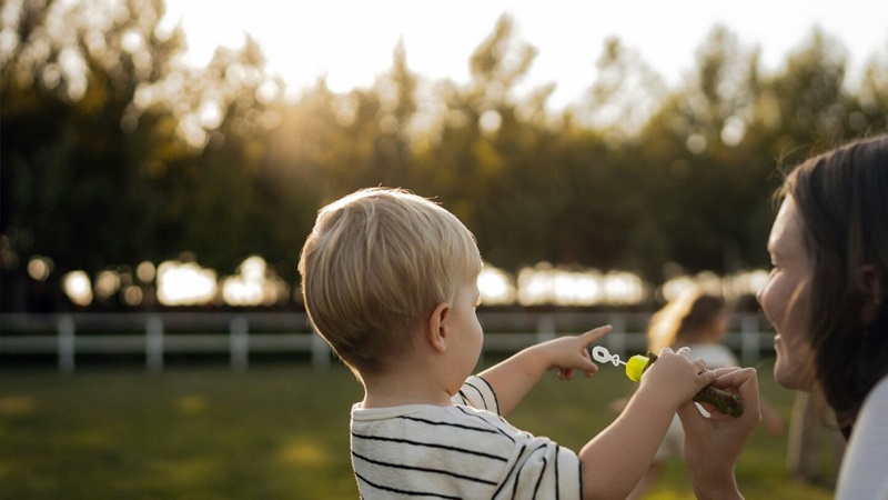 Pojke blåser såpbubblor med sin mamma