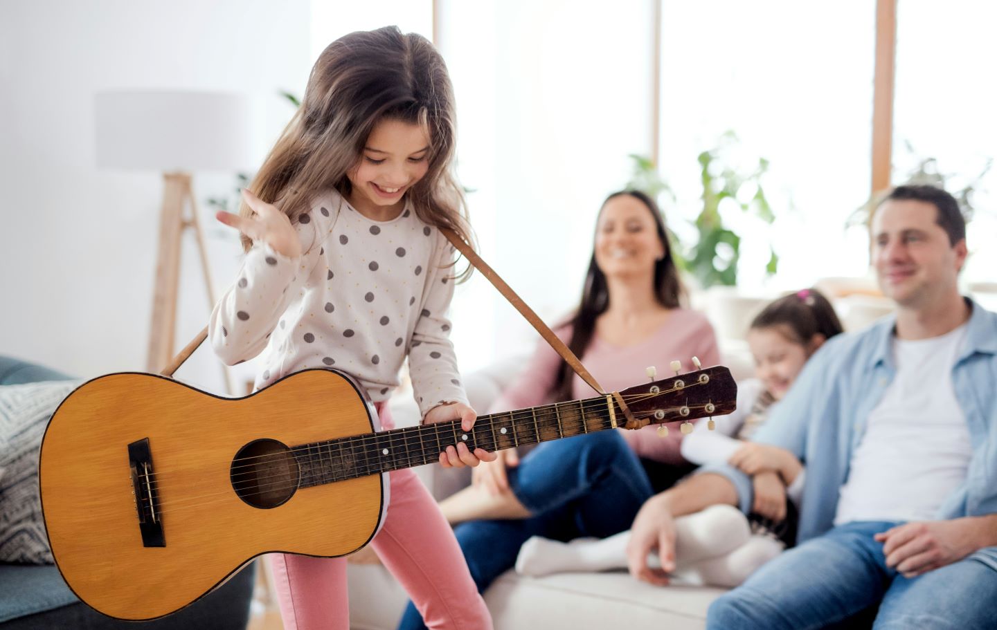Flicka med gitarr vid familj