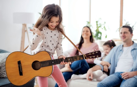 Flicka med gitarr vid familj