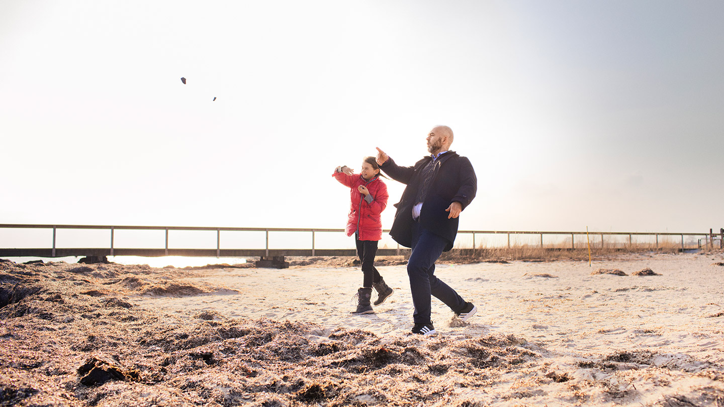 man och kvinna kastar sten på stranden