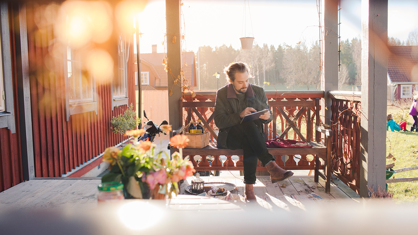 man på veranda med surfplatta