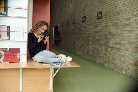 Flicka med telefon i skolan